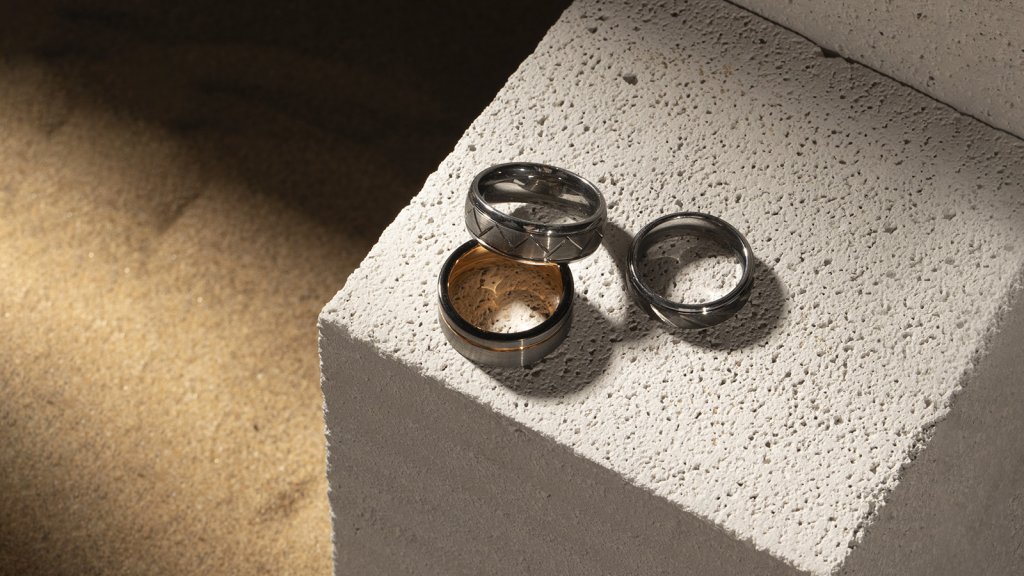 Three men's rings lay on the stone