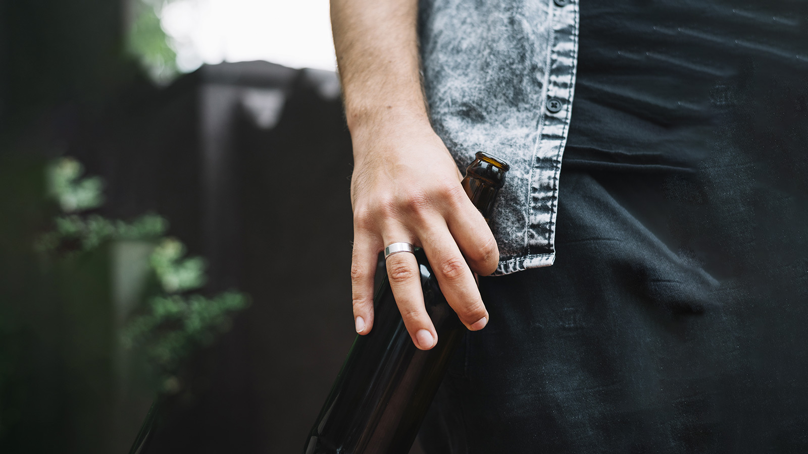 A man has a Damascus steel ring on his hand.