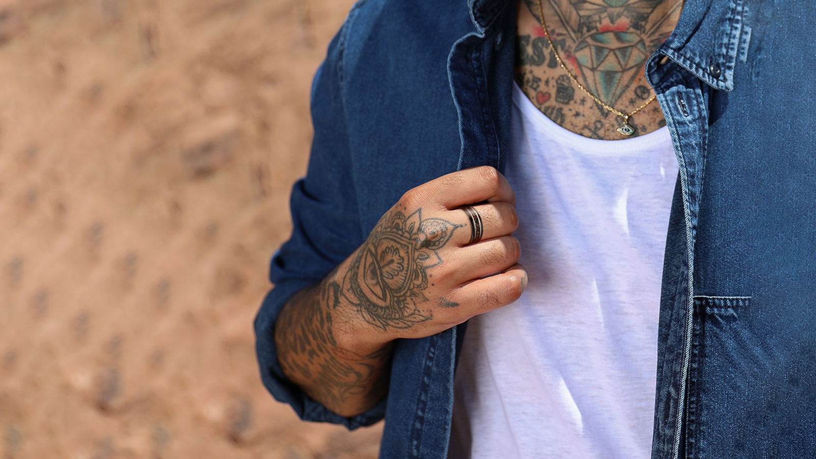 The man in the cowboy shirt wears a dinosaur bone ring on his finger